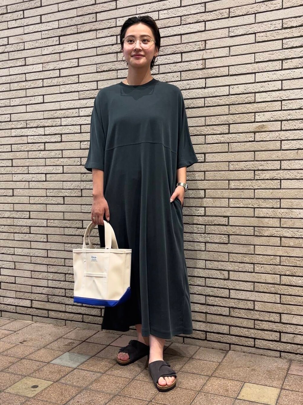 グレー系のサンダル、グリーン系のワンピースを着用したレディースの夏コーディネートの2枚目の写真