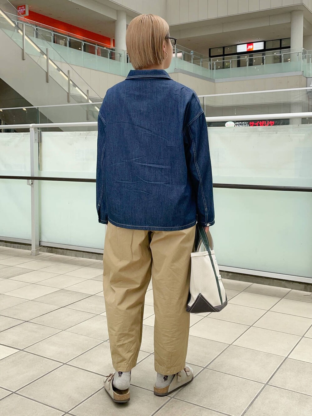 ホワイト系のトートバッグ、ベージュ系のその他パンツ、ブルー系のシャツ/ブラウスを着用したレディースの秋コーディネートの7枚目の写真