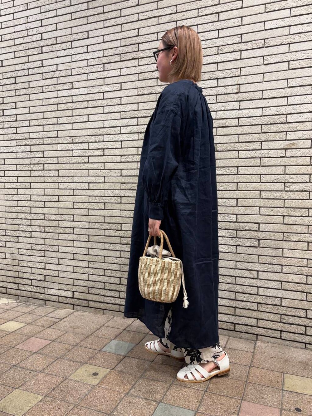 ブルー系のワンピース、ホワイト系のサンダル、グレー系のハンドバッグを着用したレディースの春コーディネートの3枚目の写真