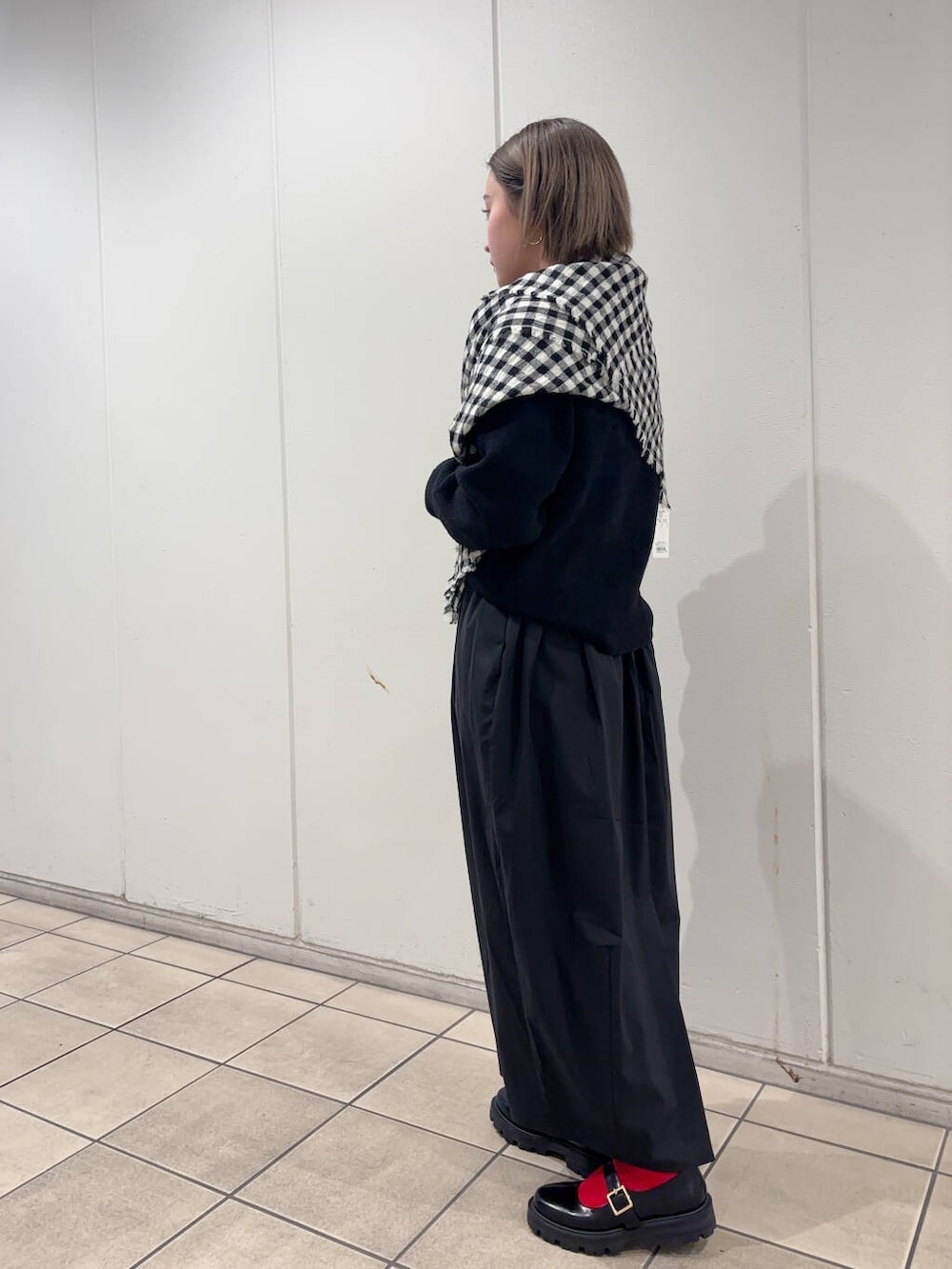 ブラック系のその他シューズ、ブラック系のニット/セーター、ブラック系のストール/ショールを着用したレディースの冬コーディネートの3枚目の写真