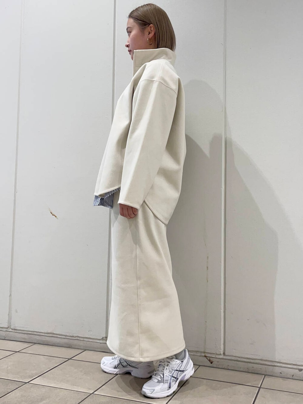 ブルー系のシャツ/ブラウス、ホワイト系のスニーカー、ホワイト系のスカートを着用したレディースの秋コーディネートの2枚目の写真