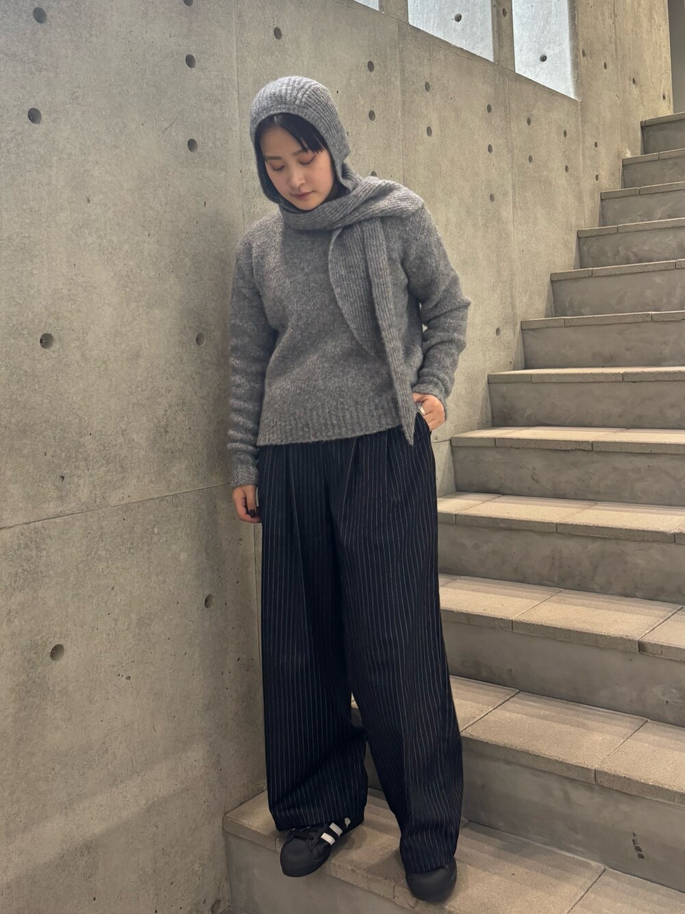 グレー系のニット/セーター、ブルー系のその他パンツ、グレー系のニットキャップ/ビーニーを着用したレディースの秋コーディネートの2枚目の写真