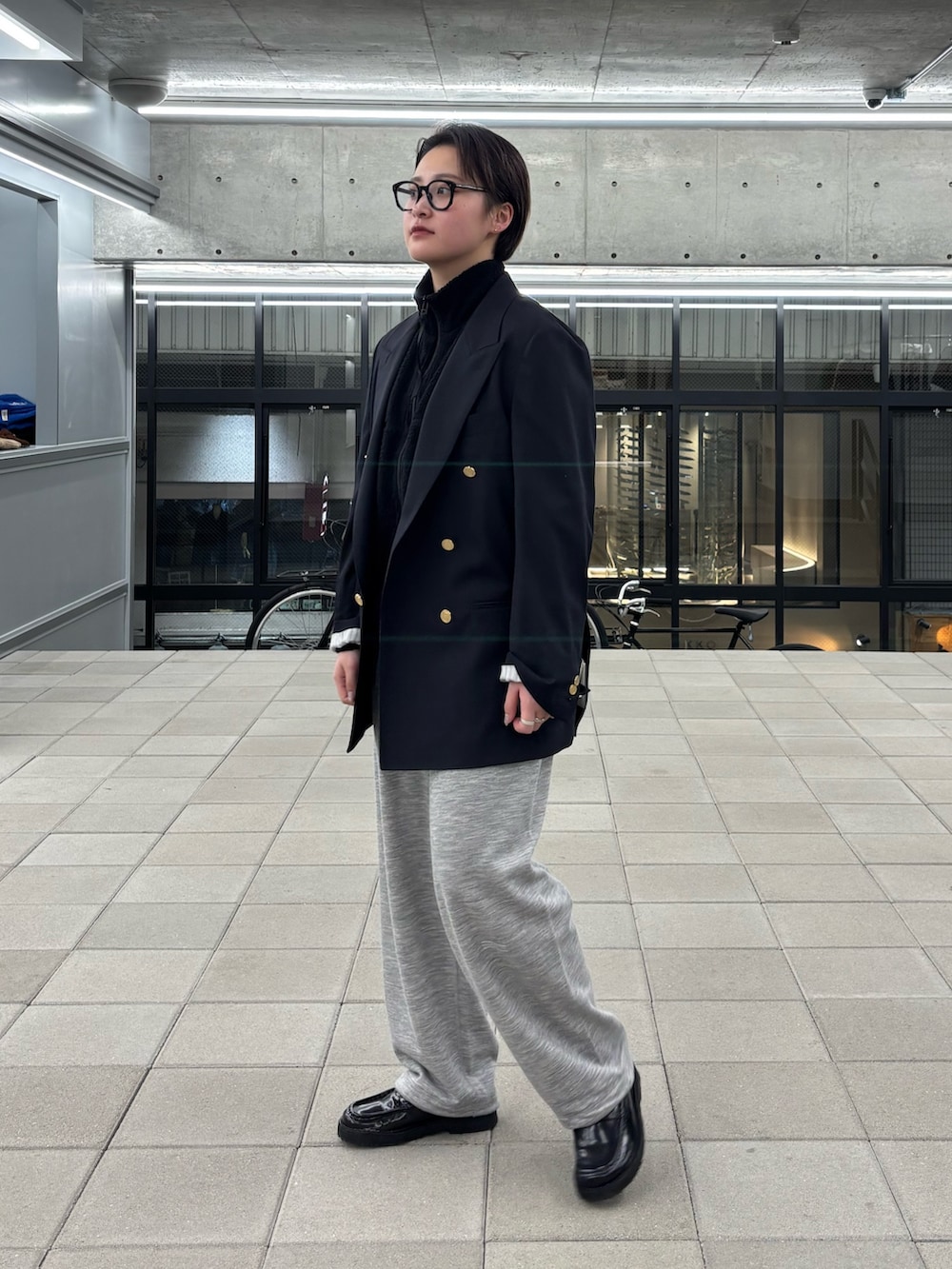 グレー系のスウェットパンツ、ブラック系のメガネを着用したレディースの冬コーディネートの2枚目の写真