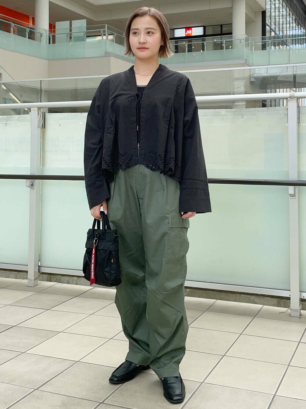 グリーン系のカーゴパンツ、ブラック系のショルダーバッグ、ブラック系のサンダルを着用したレディースの夏コーディネートの2枚目の写真