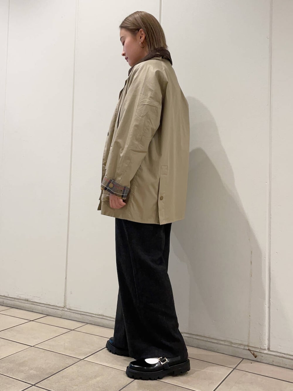 ホワイト系のニット/セーター、ブラック系のその他シューズ、ベージュ系のその他アウターを着用したレディースの秋コーディネートの2枚目の写真