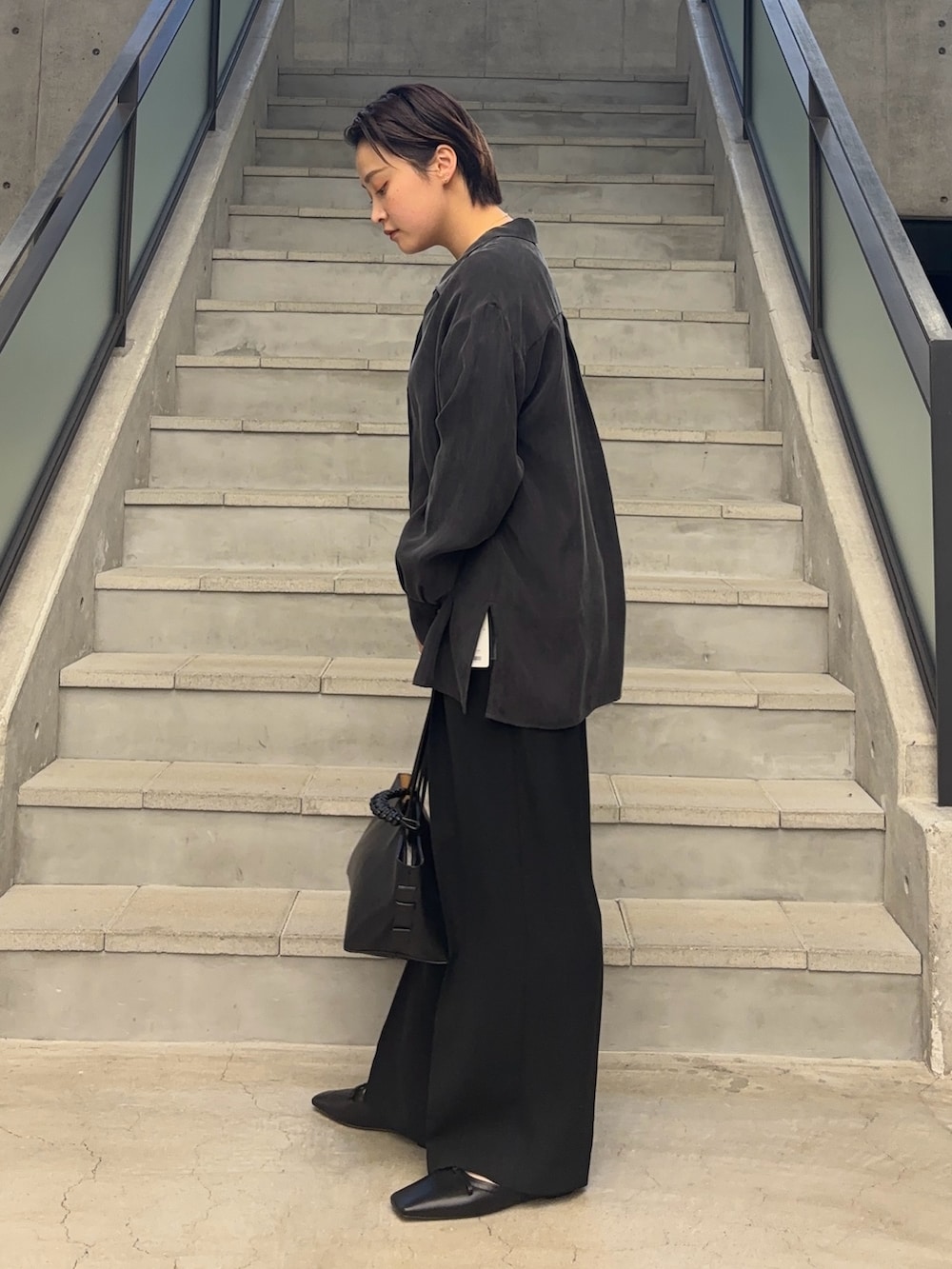 ブラック系のTシャツ/カットソー、ブラック系のトートバッグ、グレー系のシャツ/ブラウスを着用したレディースの冬コーディネートの3枚目の写真