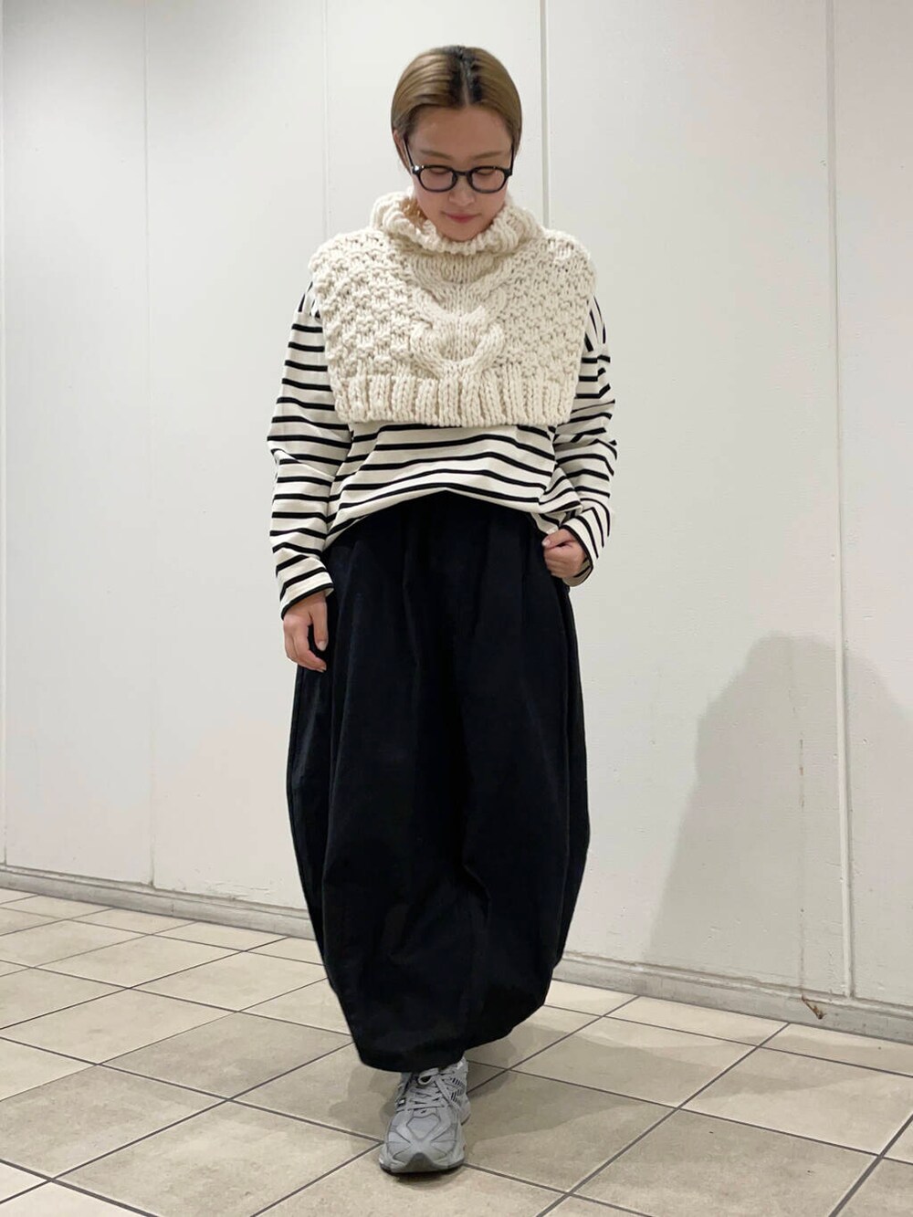 ホワイト系のTシャツ/カットソー、ブラック系のスカート、ホワイト系のネックウォーマー/スヌードを着用したレディースの冬コーディネートの3枚目の写真