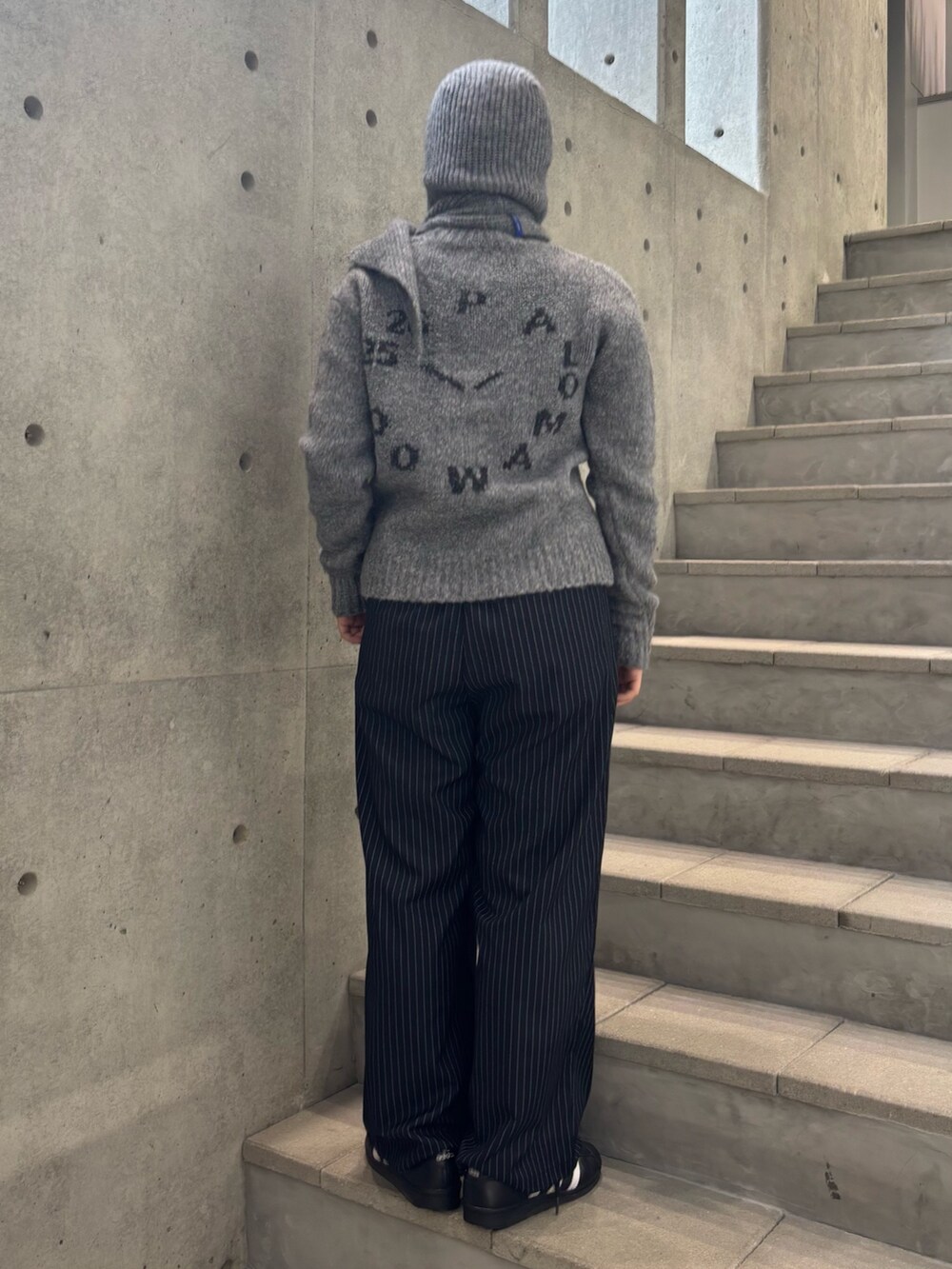 グレー系のニット/セーター、ブルー系のその他パンツ、グレー系のニットキャップ/ビーニーを着用したレディースの秋コーディネートの3枚目の写真