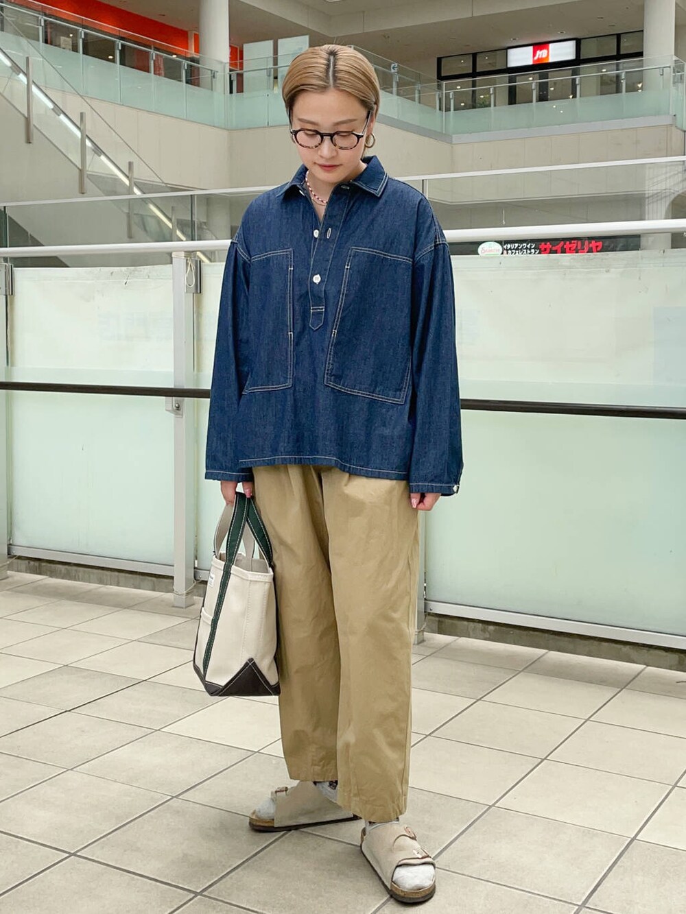 ホワイト系のトートバッグ、ベージュ系のその他パンツ、ブルー系のシャツ/ブラウスを着用したレディースの秋コーディネートの3枚目の写真