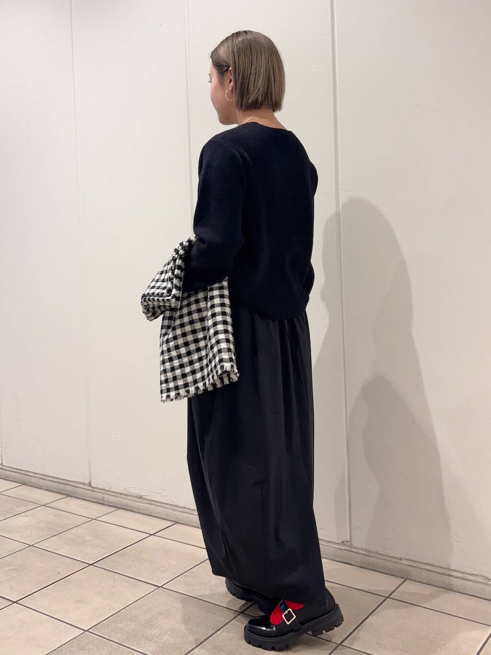 ブラック系のその他シューズ、ブラック系のニット/セーター、ブラック系のストール/ショールを着用したレディースの冬コーディネートの4枚目の写真