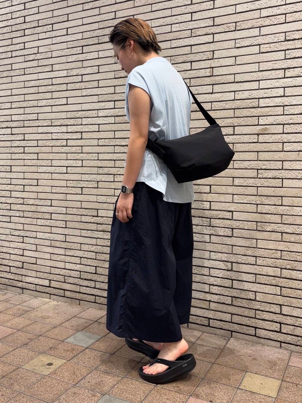 ブラック系のショルダーバッグ、ブルー系のその他パンツ、ブラック系のサンダルを着用したレディースの夏コーディネートの2枚目の写真