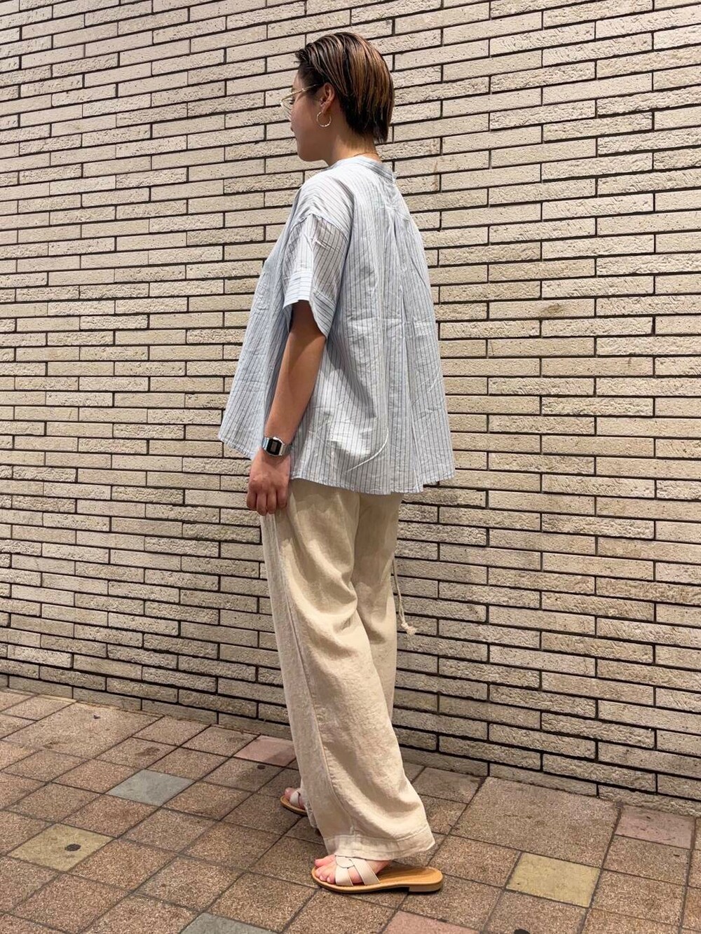 グレー系のハンドバッグ、ホワイト系のサンダル、ベージュ系のその他パンツを着用したレディースの夏コーディネートの3枚目の写真