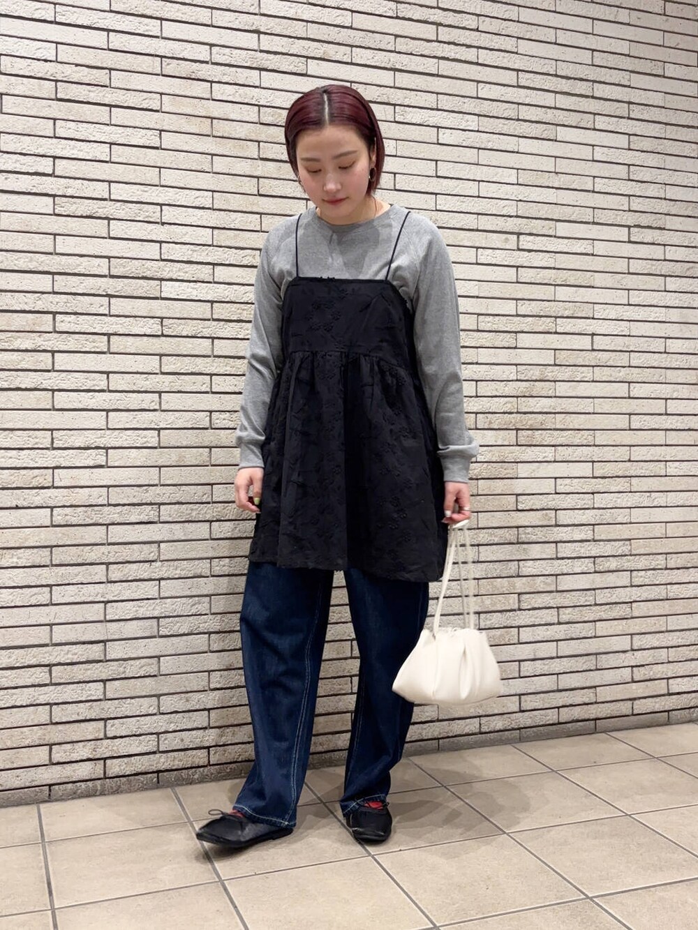 ブラック系のバレエシューズ、ホワイト系のショルダーバッグ、ブルー系のデニムパンツを着用したレディースの春コーディネートの2枚目の写真