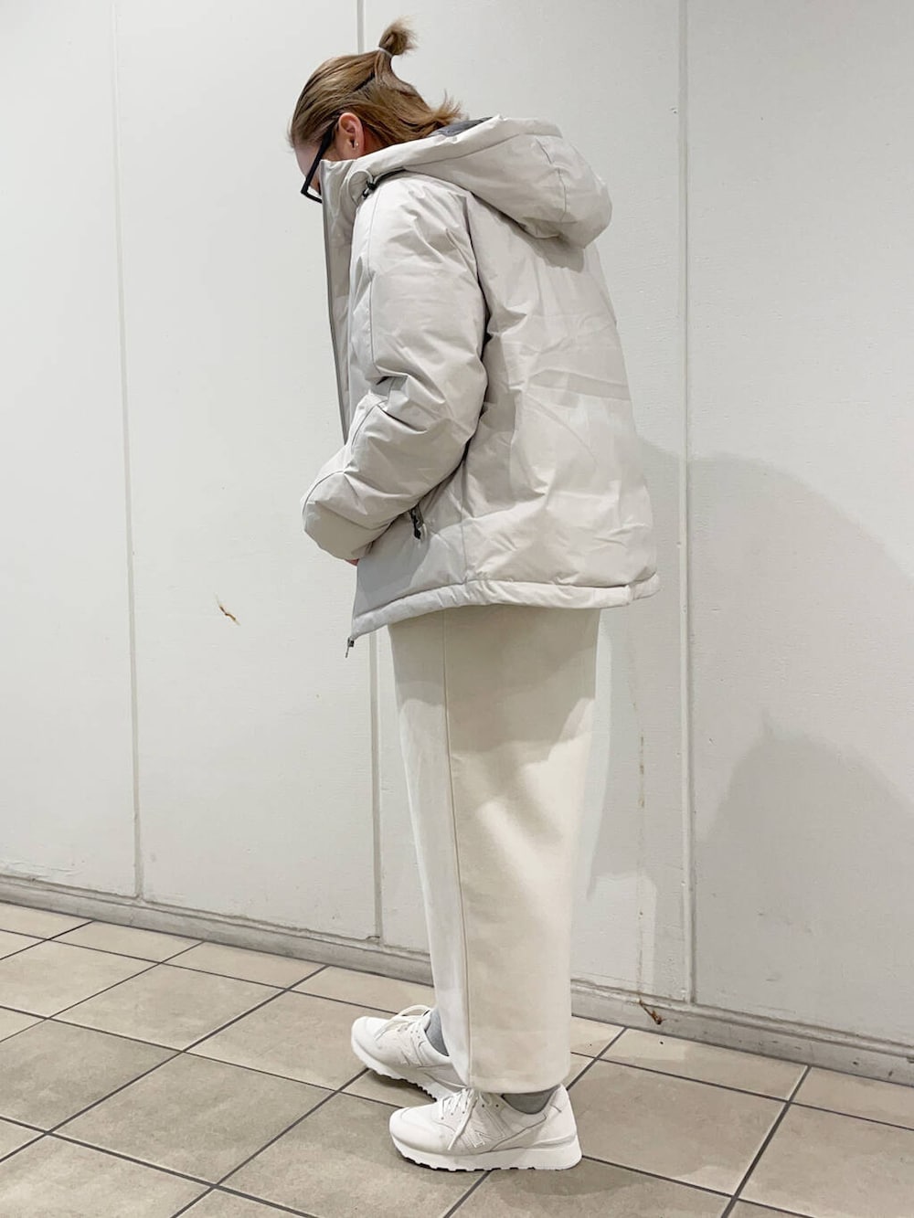 ベージュ系のTシャツ/カットソー、ホワイト系のダウンジャケット/コート、ホワイト系のスカートを着用したレディースの冬コーディネートの2枚目の写真