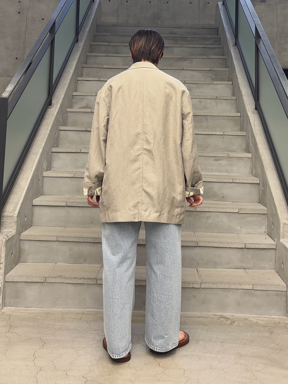 ホワイト系のタンクトップ、ブラック系のその他アウター、ブルー系のデニムパンツを着用したレディースの春コーディネートの4枚目の写真