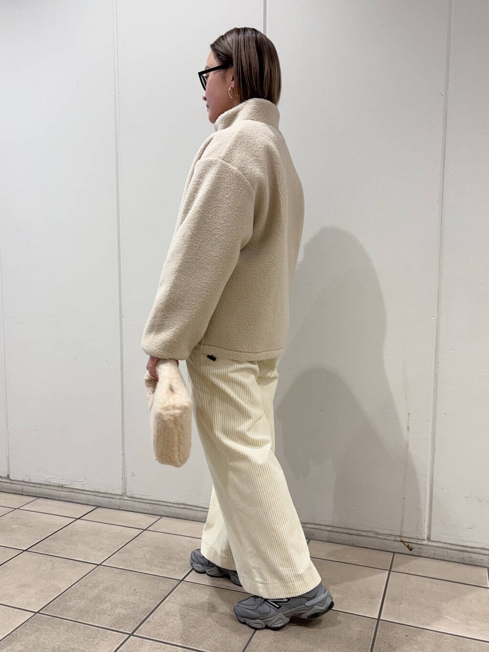 ベージュ系のハンドバッグ、ホワイト系のブルゾン、ホワイト系のその他パンツを着用したレディースの冬コーディネートの3枚目の写真