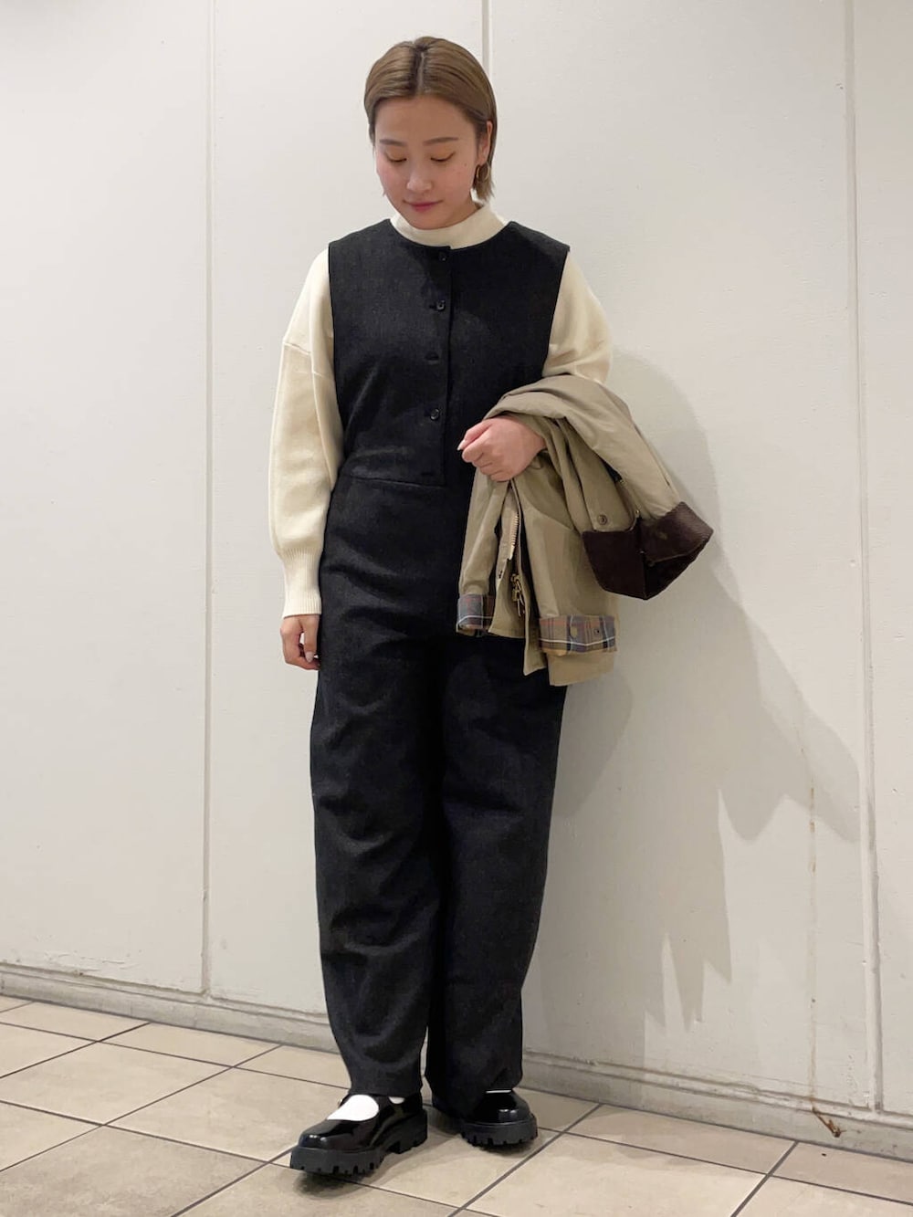 ホワイト系のニット/セーター、ブラック系のその他シューズ、ベージュ系のその他アウターを着用したレディースの秋コーディネートの4枚目の写真