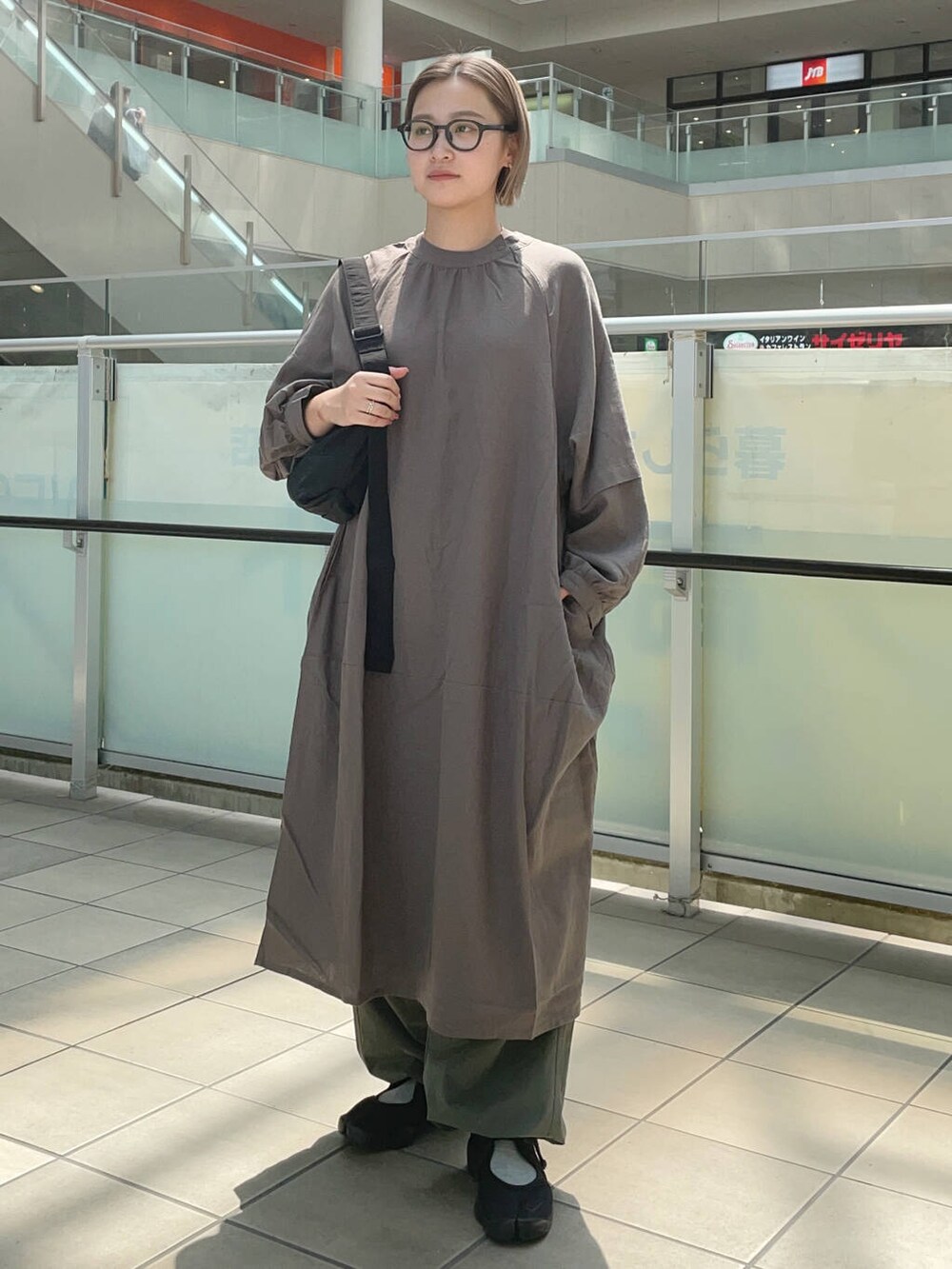 ブラック系のショルダーバッグ、グレー系のワンピース、グリーン系のその他パンツを着用したレディースの夏コーディネートの2枚目の写真