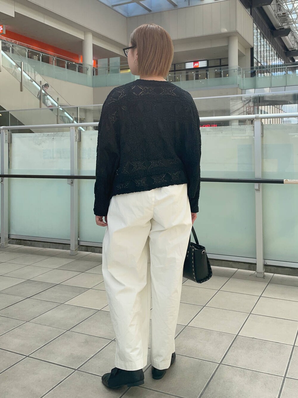 ブラック系のショルダーバッグ、ブラック系のその他シューズ、ホワイト系のその他パンツを着用したレディースの夏コーディネートの3枚目の写真