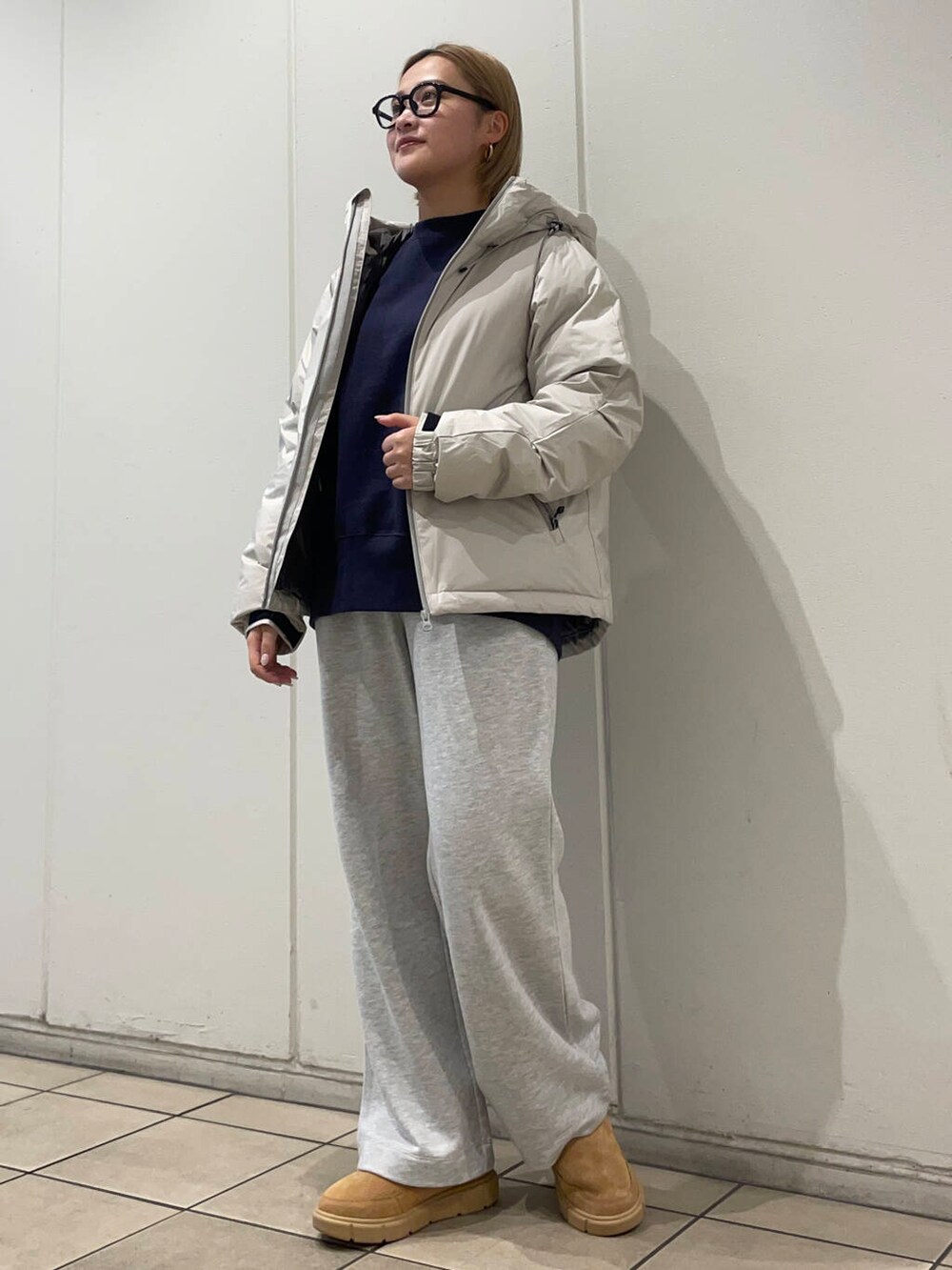 ホワイト系のダウンジャケット/コート、ブルー系のスウェット、グレー系のその他パンツを着用したレディースの秋コーディネートの2枚目の写真
