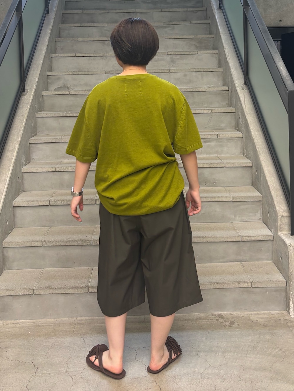 グリーン系のニット/セーター、ブラウン系のその他パンツ、ブラウン系のサンダルを着用したレディースの夏コーディネートの2枚目の写真