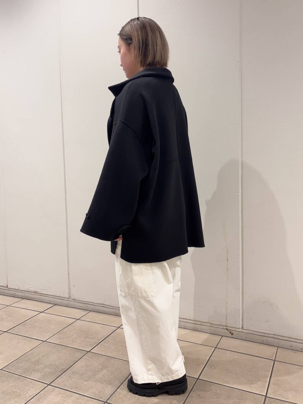 ブラック系のその他シューズ、ホワイト系のその他パンツ、ベージュ系のTシャツ/カットソーを着用したレディースの冬コーディネートの3枚目の写真