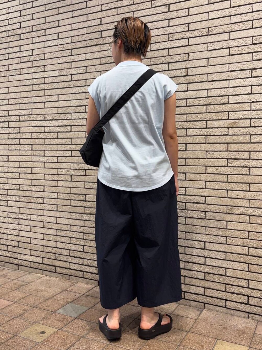 ブラック系のショルダーバッグ、ブルー系のその他パンツ、ブラック系のサンダルを着用したレディースの夏コーディネートの3枚目の写真