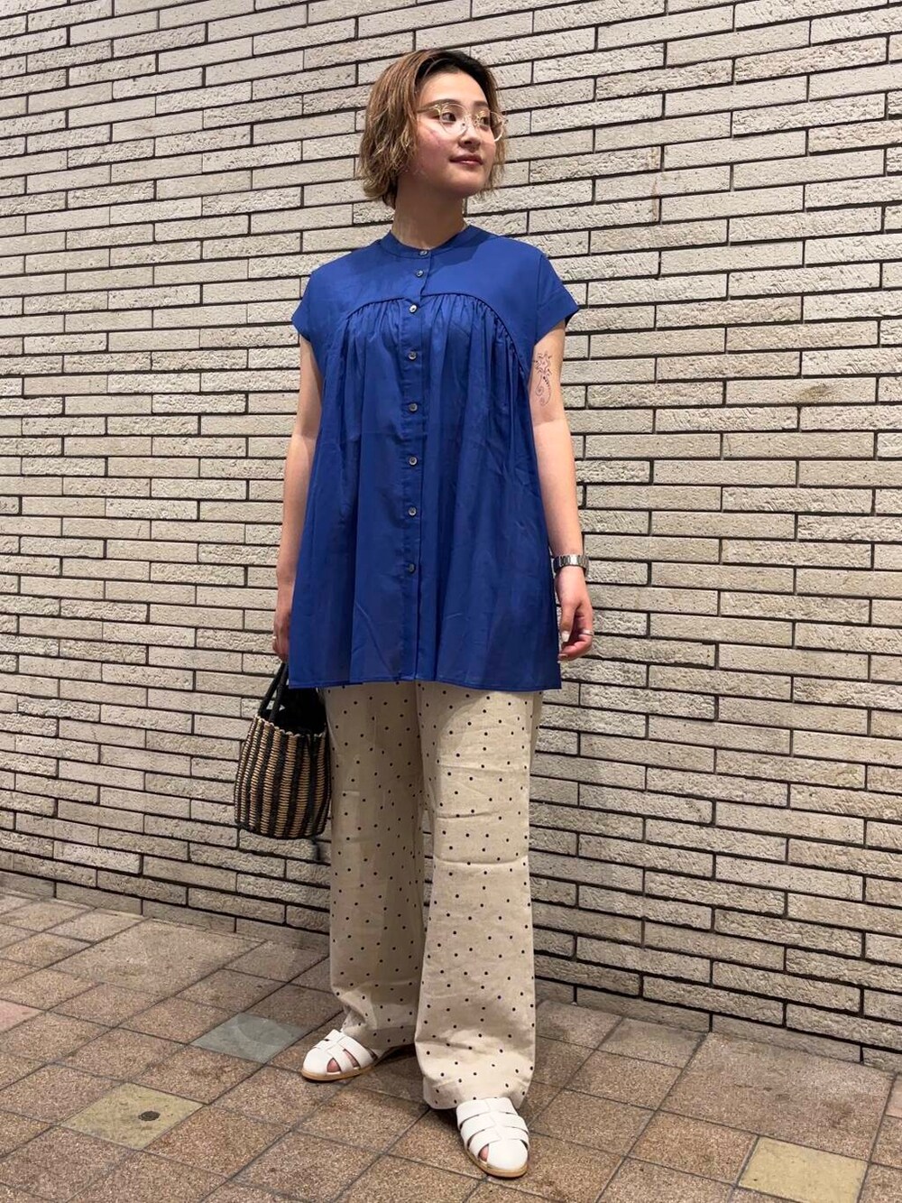 ベージュ系のその他パンツ、ホワイト系のサンダル、ブラック系のハンドバッグを着用したレディースの春コーディネートの2枚目の写真