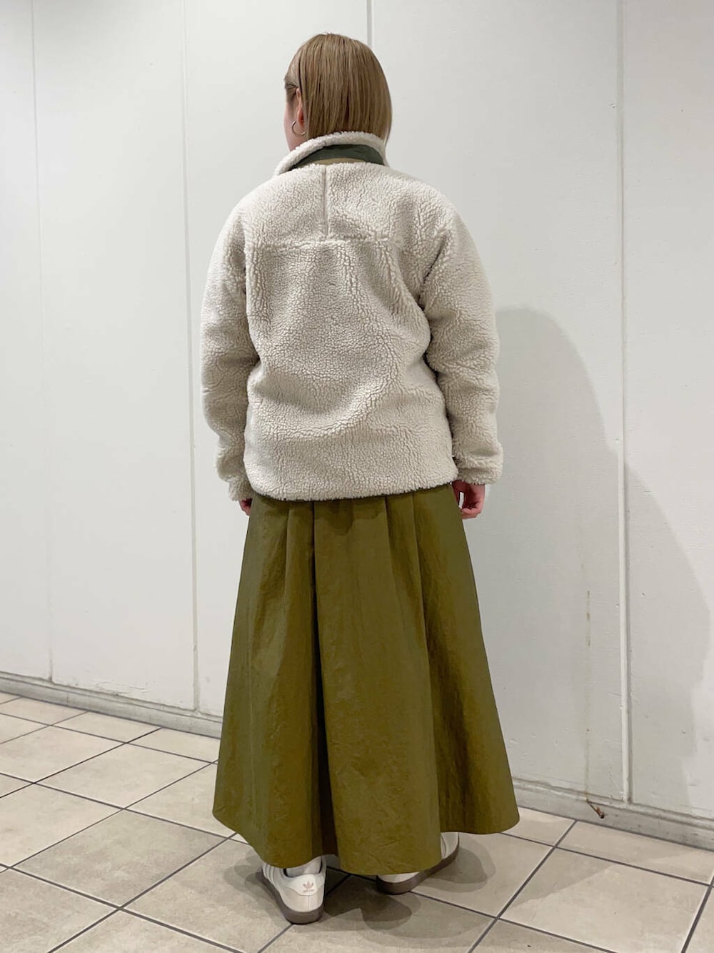 ホワイト系のスニーカー、グリーン系のスカート、グレー系のスウェットを着用したレディースの秋コーディネートの3枚目の写真