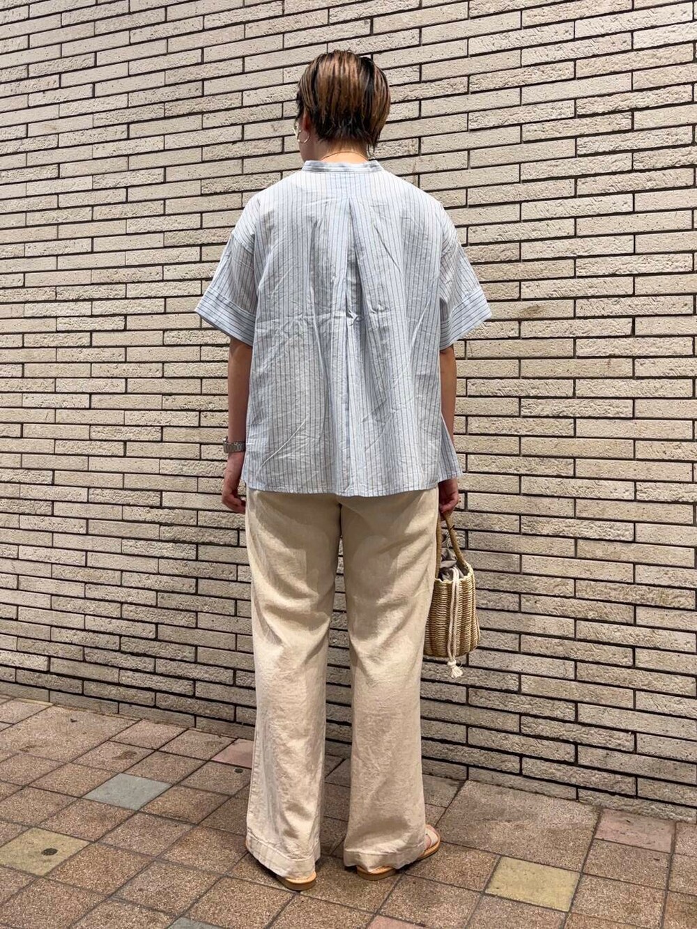 グレー系のハンドバッグ、ホワイト系のサンダル、ベージュ系のその他パンツを着用したレディースの夏コーディネートの4枚目の写真