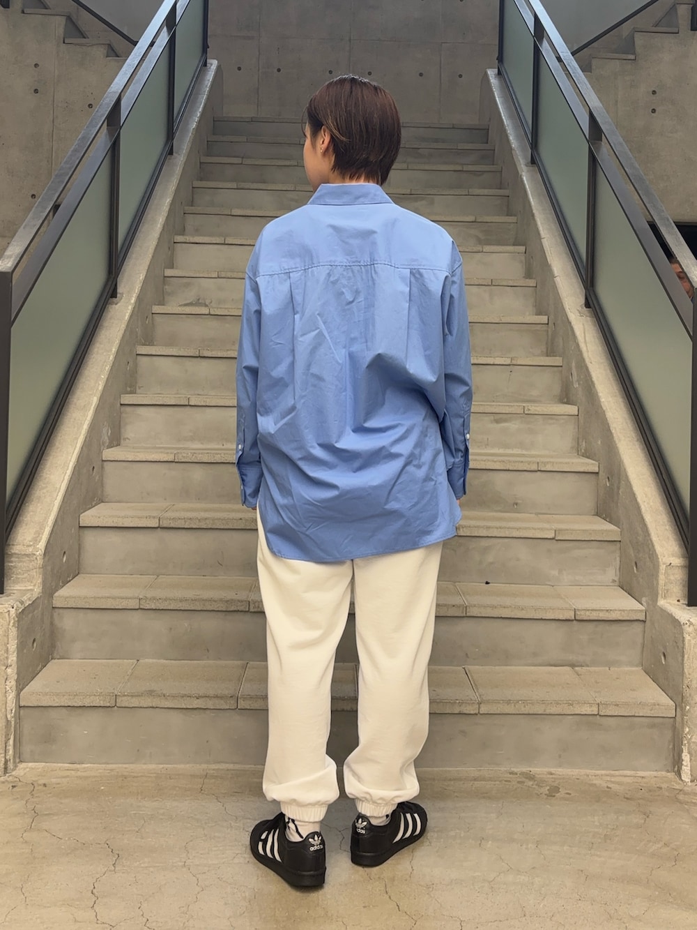 ブルー系のシャツ/ブラウス、ブルー系のタンクトップ、ホワイト系のスウェットパンツを着用したレディースの春コーディネートの3枚目の写真