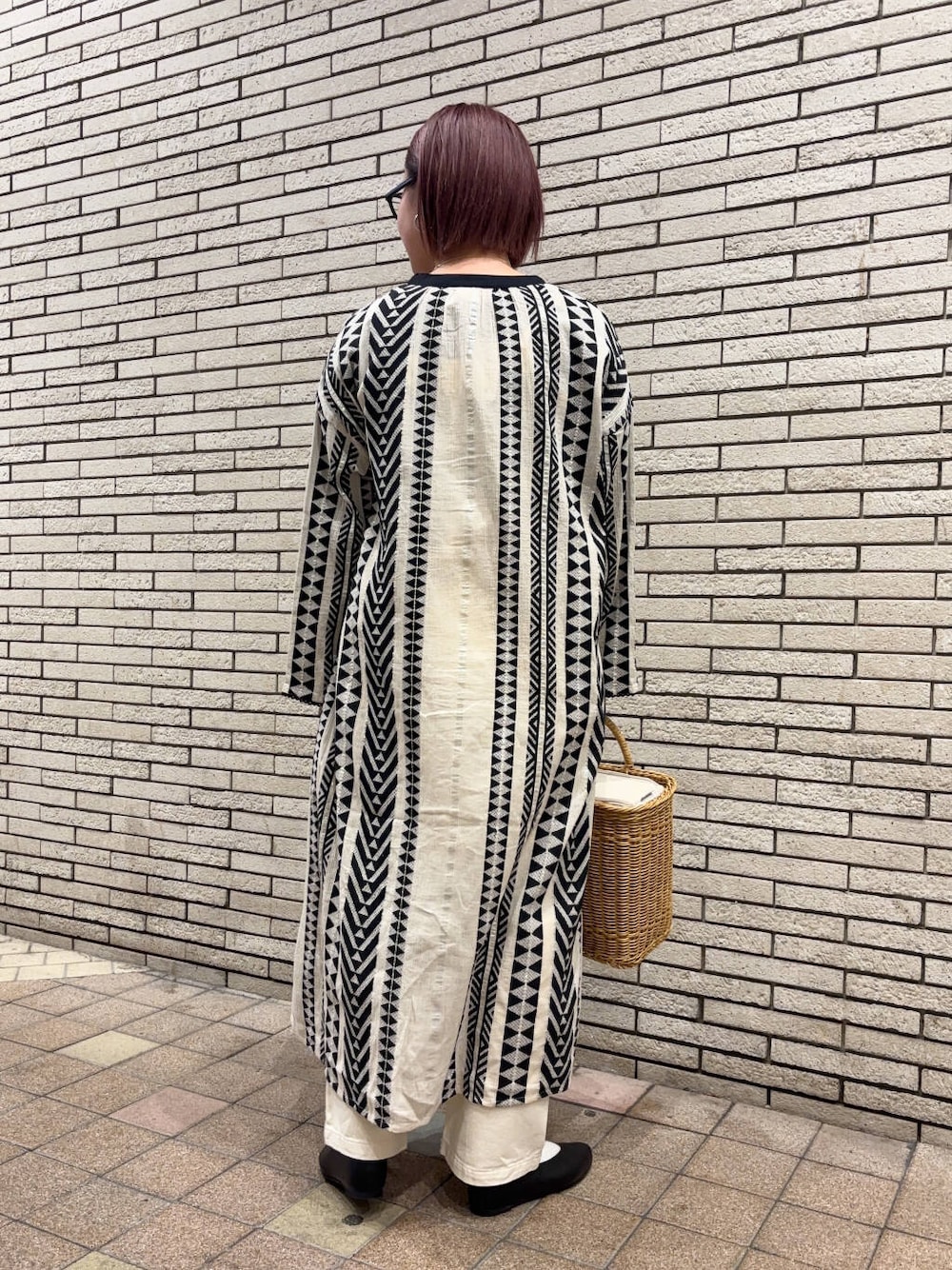 ベージュ系のデニムパンツ、ベージュ系のかごバッグ、ブラック系のパンプスを着用したレディースの春コーディネートの3枚目の写真