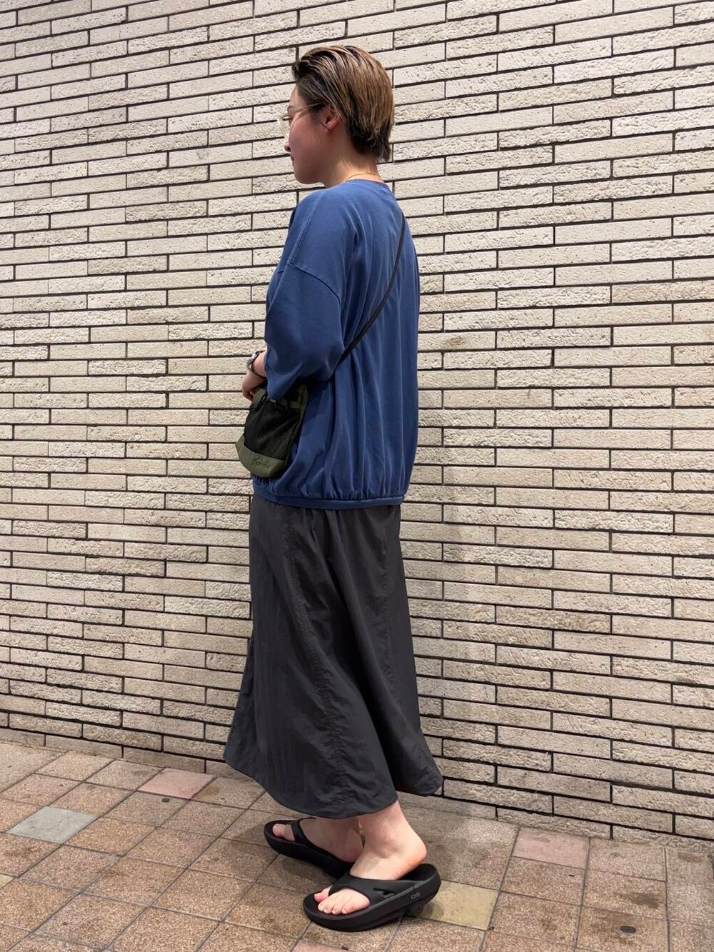 ブラック系のサンダル、グリーン系のショルダーバッグ、グレー系のスカートを着用したレディースの夏コーディネートの3枚目の写真