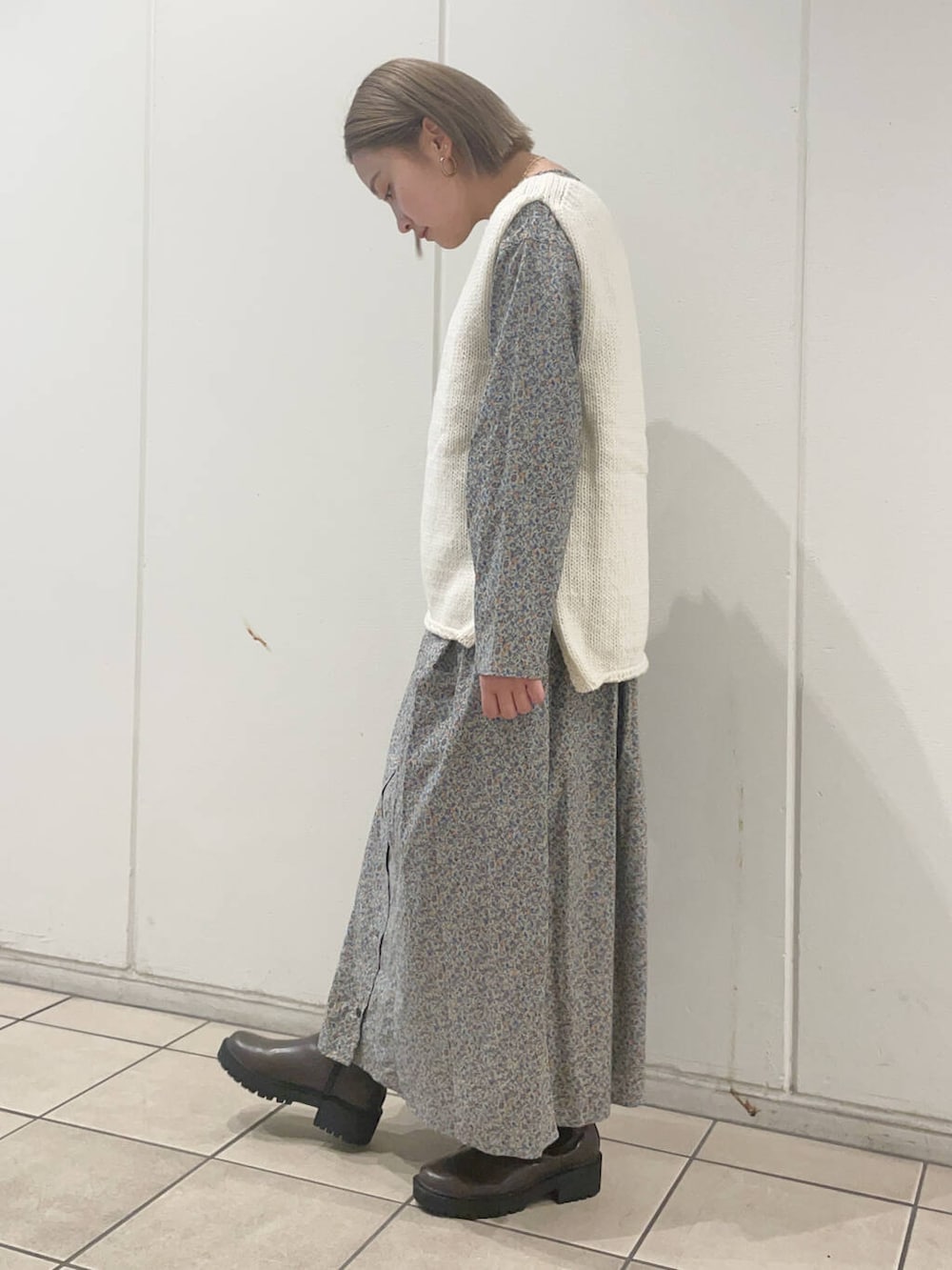 ホワイト系のニット/セーター、ブラウン系のブーツ、グレー系のワンピースを着用したレディースの秋コーディネートの3枚目の写真