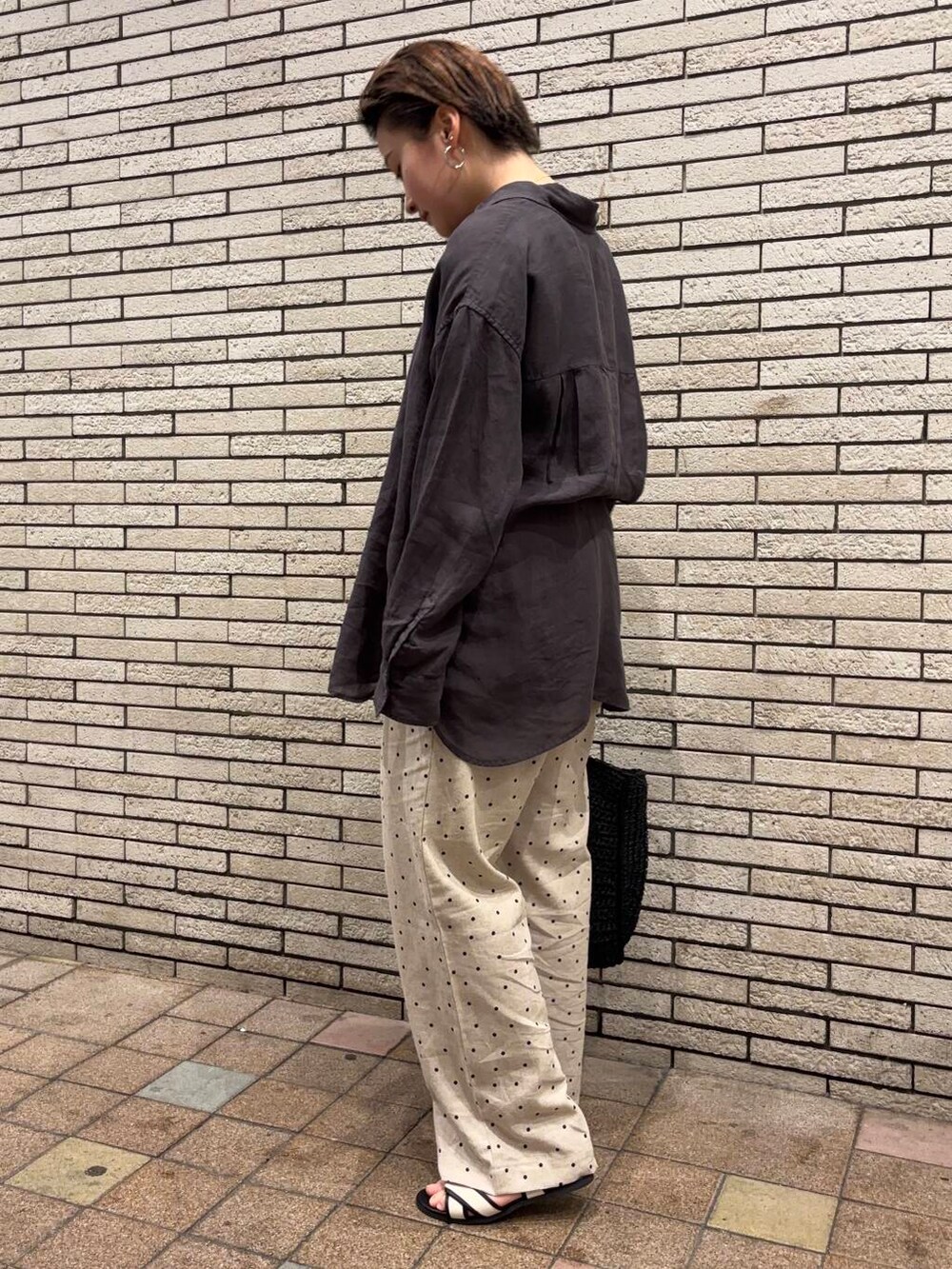 ブラック系のトートバッグ、ホワイト系のサンダル、ベージュ系のその他パンツを着用したレディースの夏コーディネートの2枚目の写真