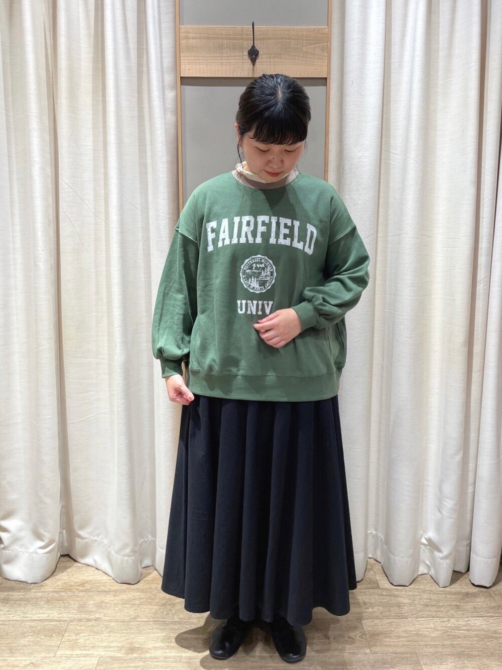 ベージュ系のステンカラーコート、ホワイト系のTシャツ/カットソー、グリーン系のTシャツ/カットソーを着用したレディースの秋コーディネートの2枚目の写真