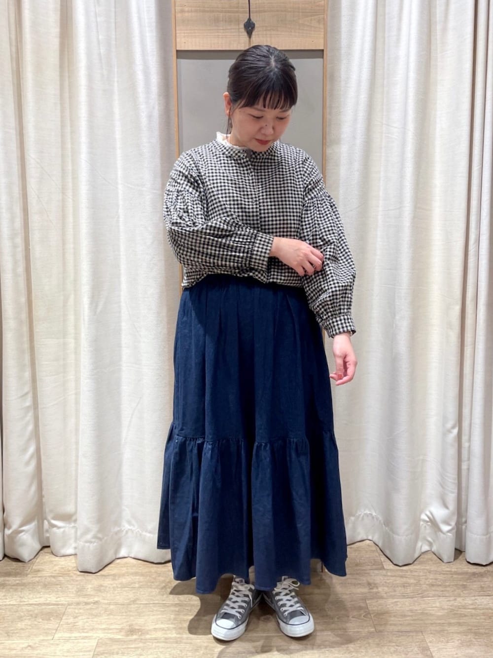 ホワイト系のTシャツ/カットソー、ブラック系のチュニック、ブルー系のデニムスカートを着用したレディースの秋コーディネートの2枚目の写真