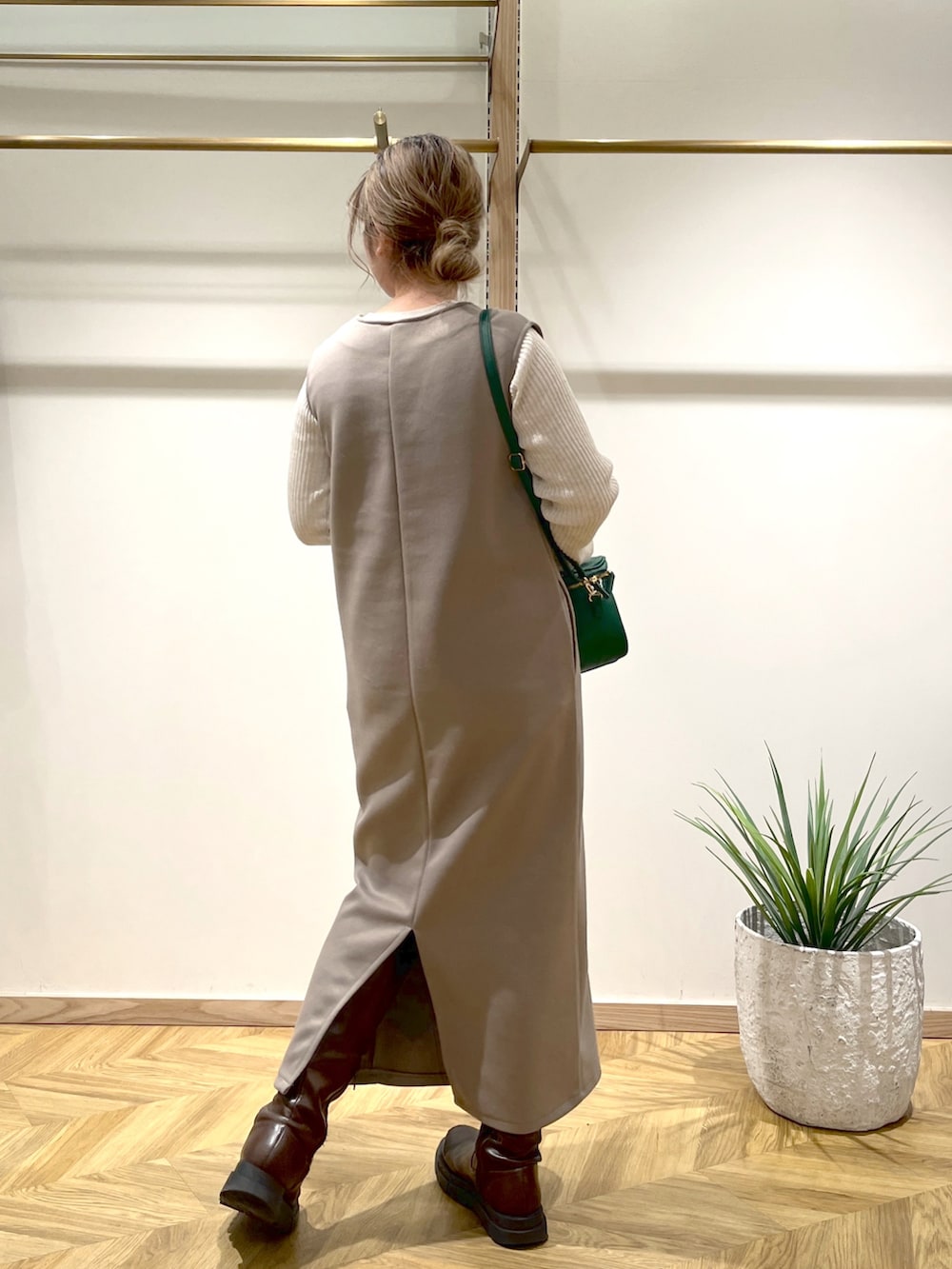 ホワイト系のニット/セーター、ブラウン系のワンピース、グリーン系のショルダーバッグを着用したレディースの春コーディネートの3枚目の写真