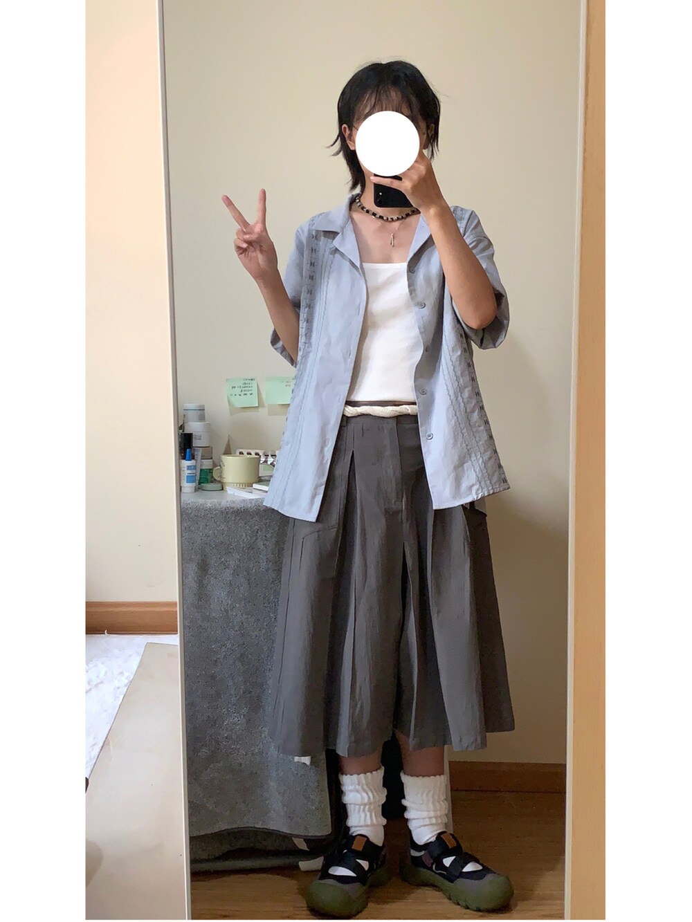 グレー系のスカートを着用したレディースの夏コーディネートの2枚目の写真