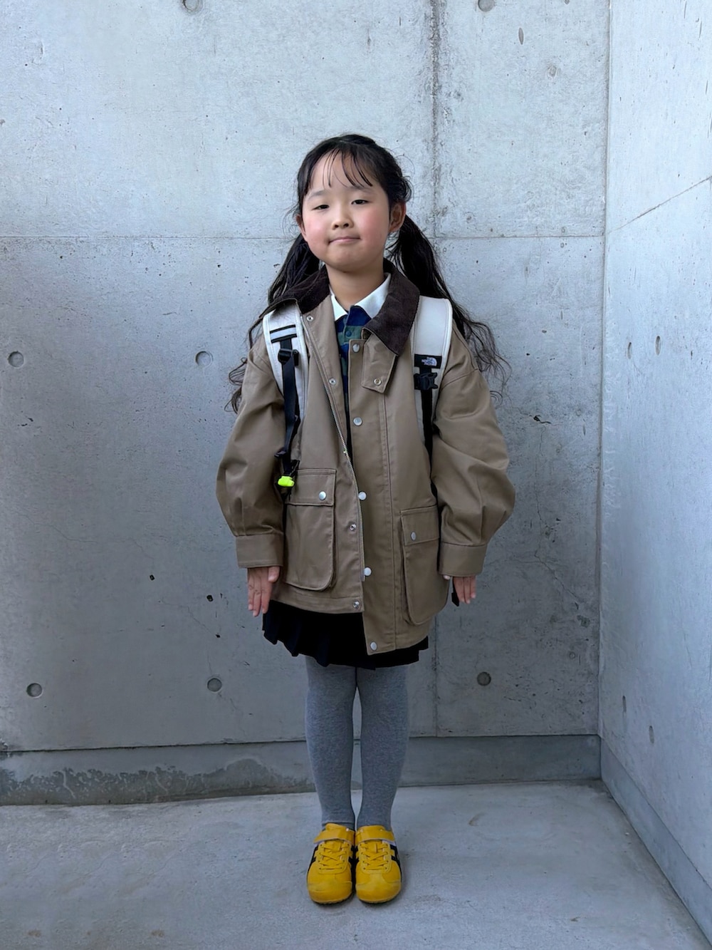 グリーン系のポロシャツ、ベージュ系のミリタリージャケット、イエロー系のスニーカーを着用したキッズの冬コーディネートの4枚目の写真