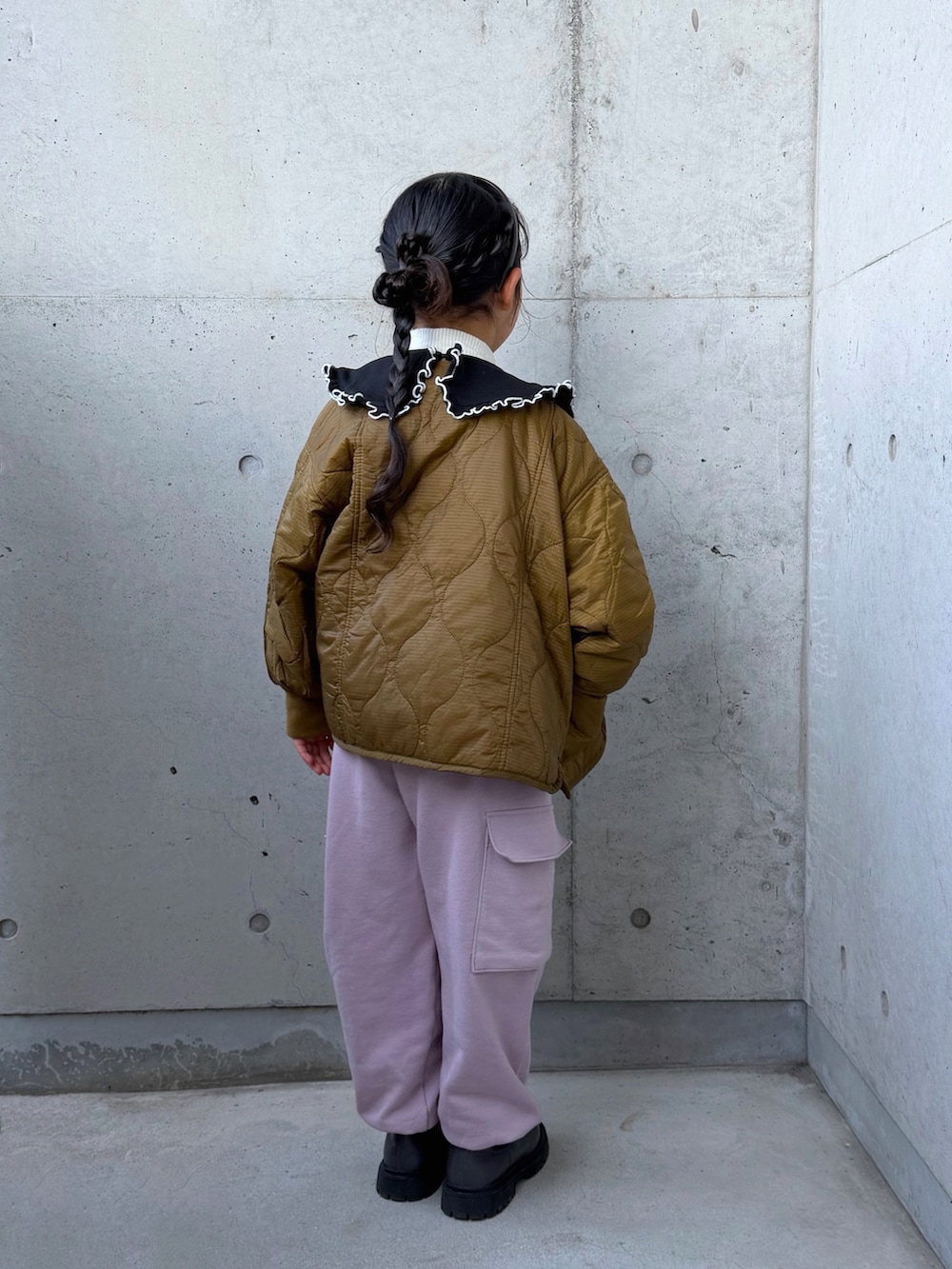 ブラック系のスウェット、ピンク系のカーゴパンツ、グレー系のブーツを着用したキッズの冬コーディネートの3枚目の写真