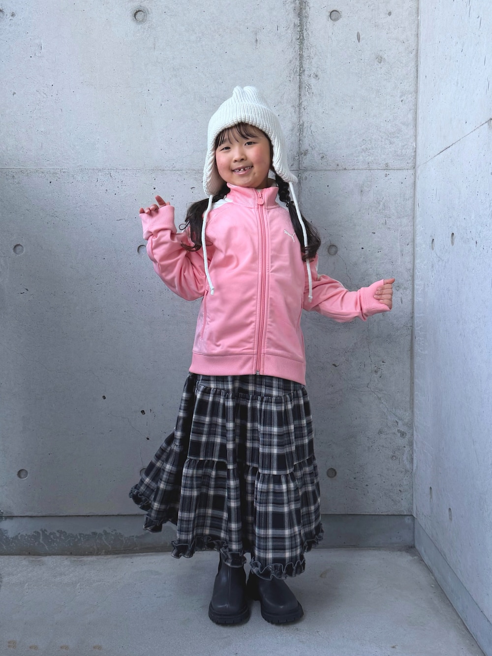 グレー系のブーツ、ピンク系のジャージ、ブラウン系のスカートを着用したキッズの冬コーディネートの5枚目の写真