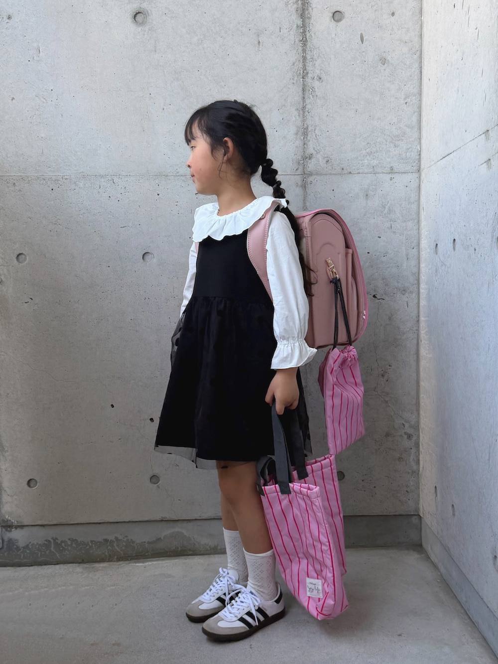 ホワイト系のシャツ/ブラウス、ブラック系のワンピース、ピンク系のトートバッグを着用したキッズの春コーディネートの4枚目の写真