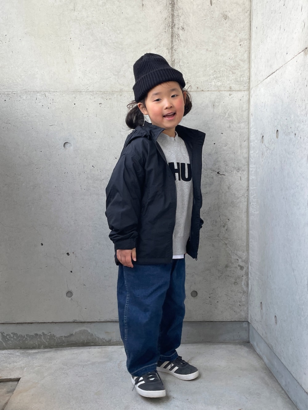 ブラック系のナイロンジャケット、グレー系のスウェット、ブルー系のデニムパンツを着用したキッズの冬コーディネートの5枚目の写真