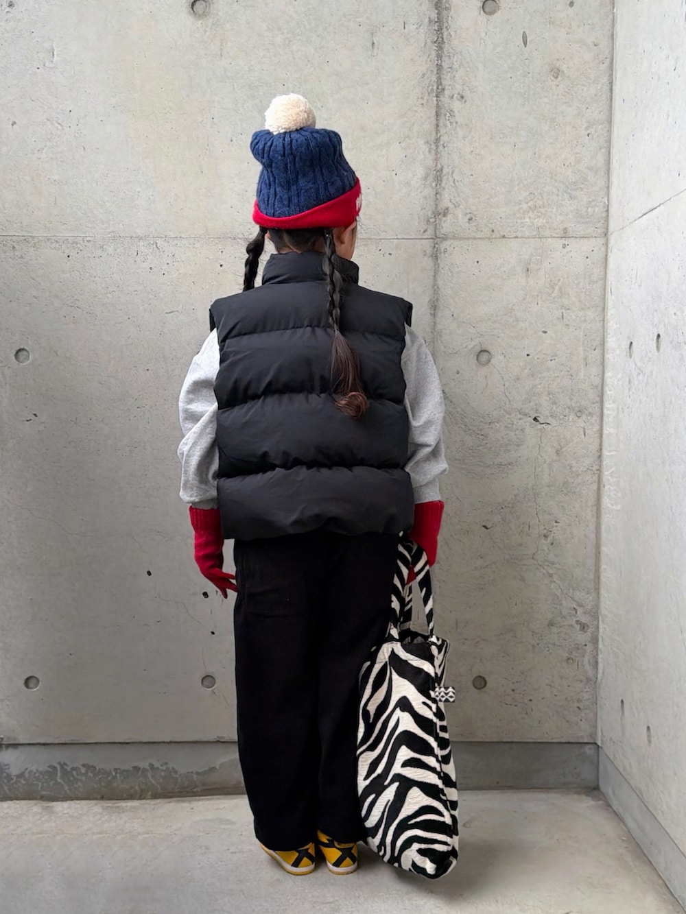 グレー系のスウェット、イエロー系のスニーカー、ブラック系のサロペット/オーバーオールを着用したキッズの冬コーディネートの4枚目の写真