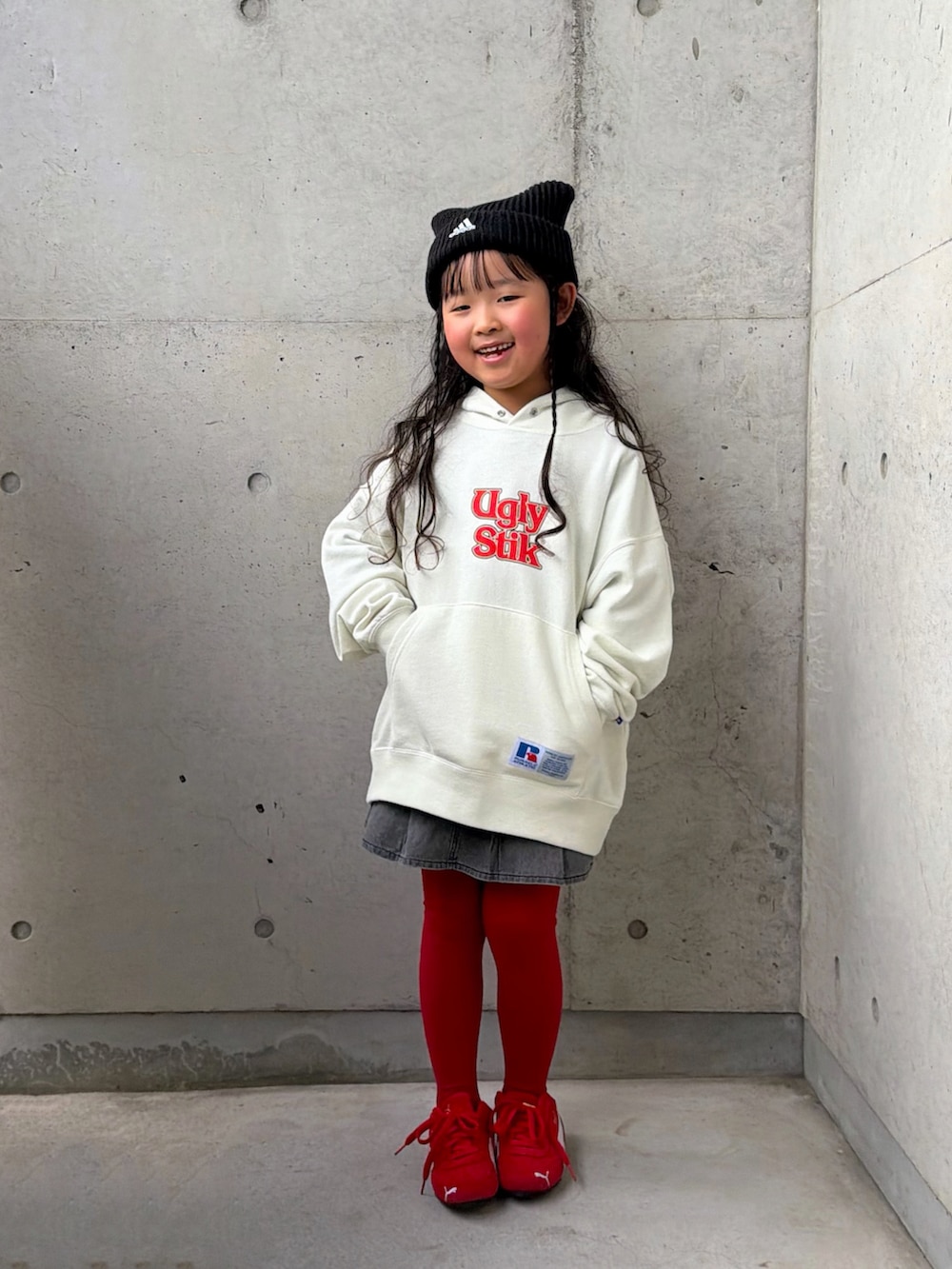 ホワイト系のパーカー、レッド系のスニーカー、グレー系のスカートを着用したキッズの冬コーディネートの3枚目の写真
