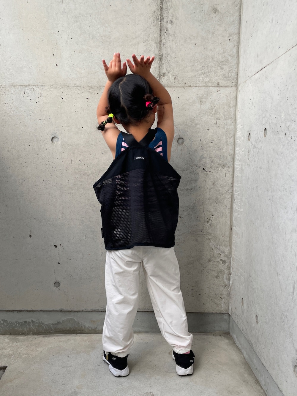 ブルー系のタンクトップ、ブラック系のベスト、ホワイト系のカーゴパンツを着用したキッズの春コーディネートの5枚目の写真
