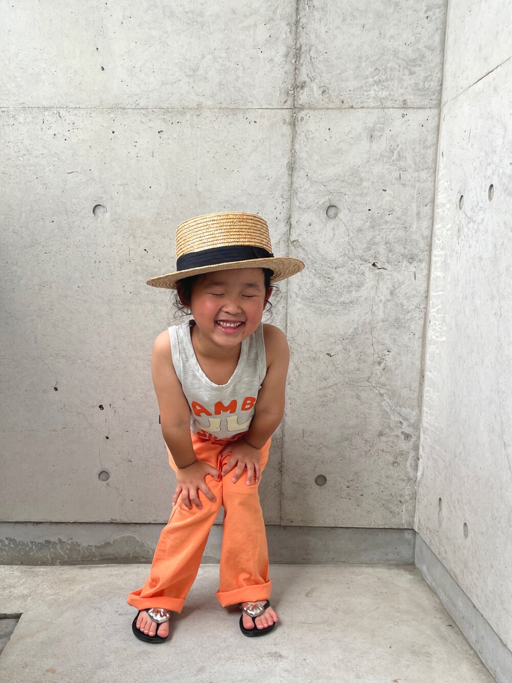 グレー系のトップス、ブラック系のサンダル、オレンジ系のその他パンツを着用したキッズの夏コーディネートの2枚目の写真