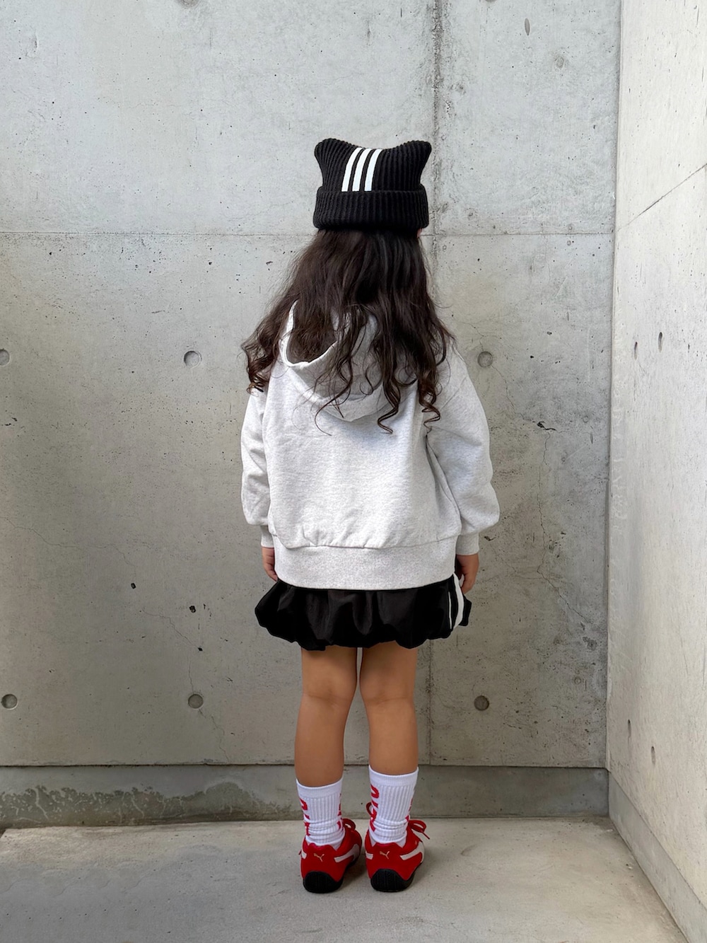 グレー系のスウェット、ブラック系のスカート、レッド系のスニーカーを着用したキッズの秋コーディネートの4枚目の写真