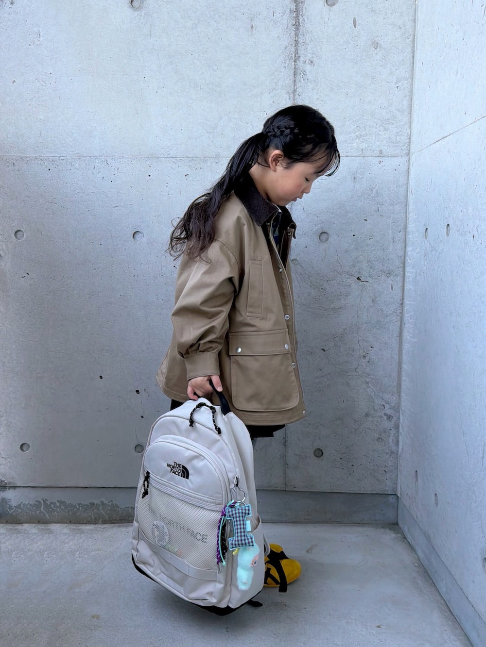 グリーン系のポロシャツ、ベージュ系のミリタリージャケット、イエロー系のスニーカーを着用したキッズの冬コーディネートの5枚目の写真